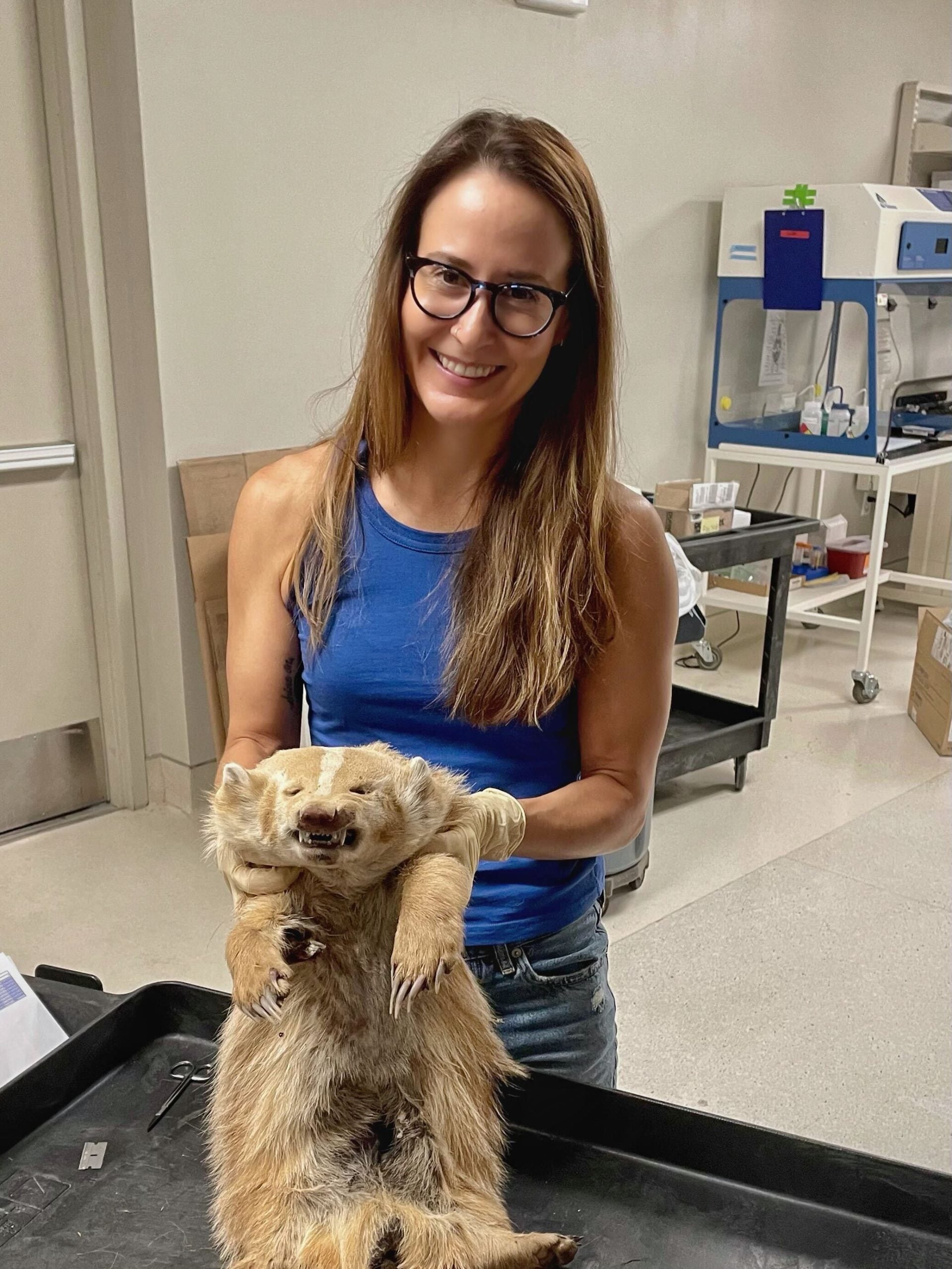 Kristen proudly holds up the carcass of a leucistic (blonde) badger
